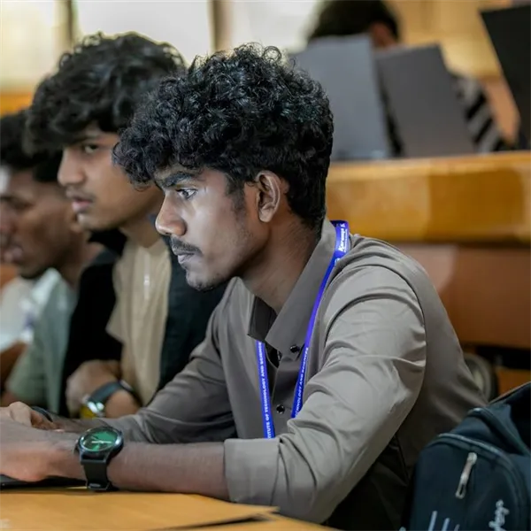 Student working on a laptop in a lecture hall
