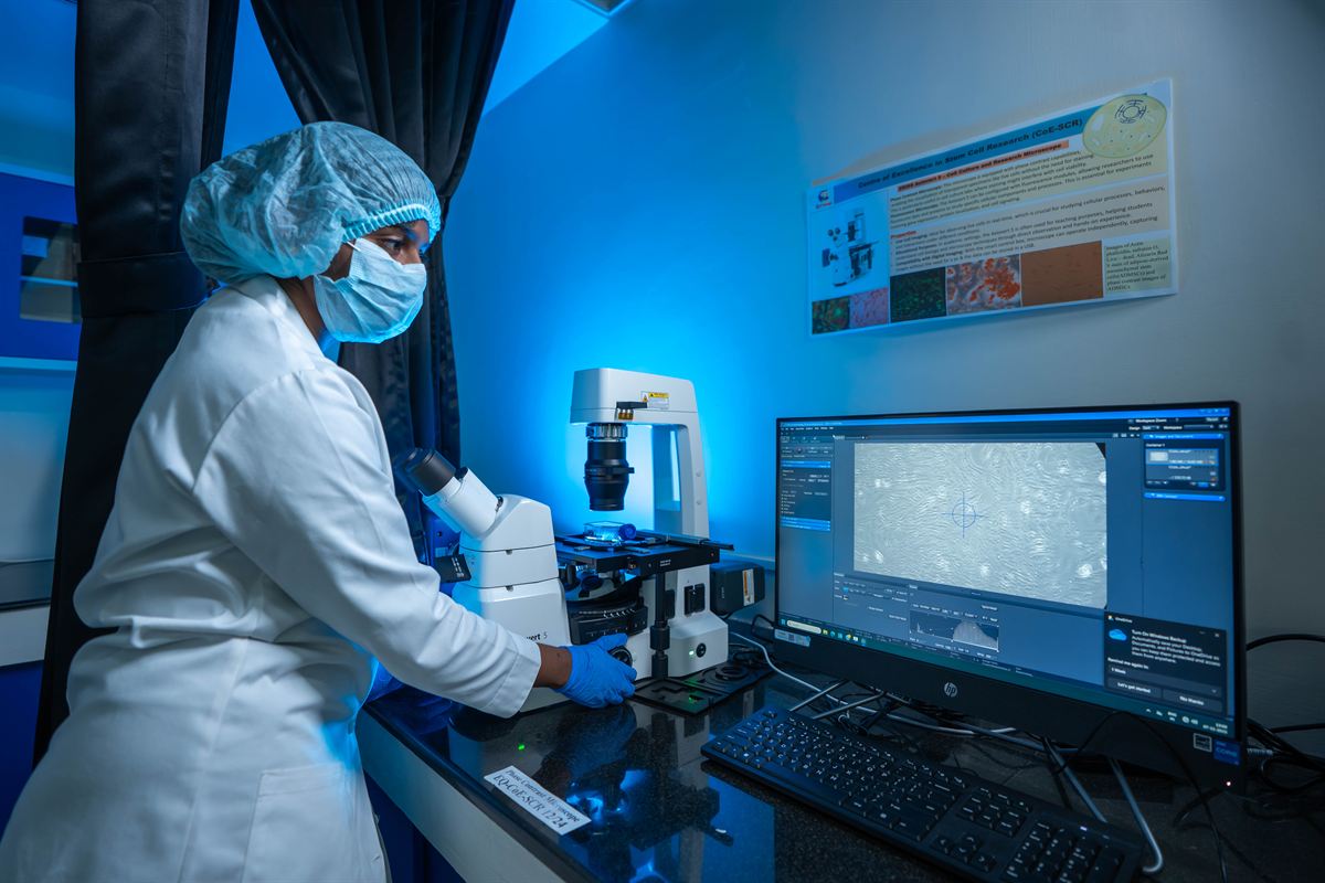 Researcher using an advanced microscope with live imaging in a Karunya research laboratory